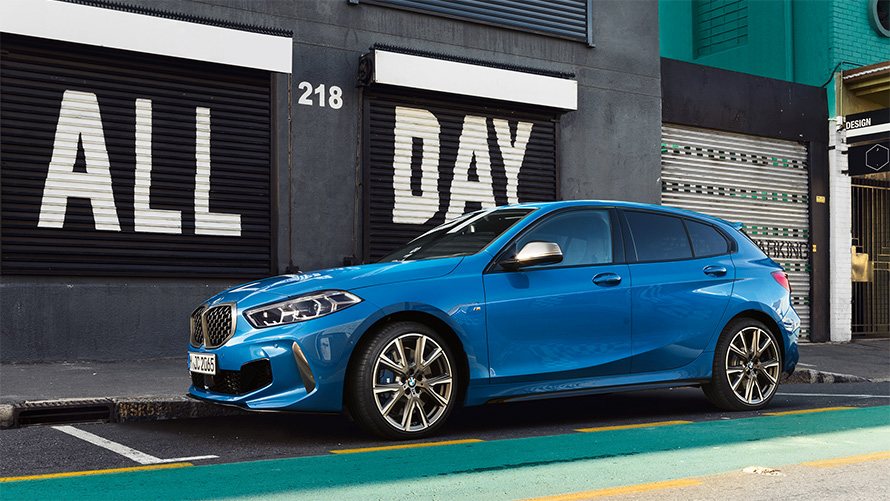 BMW 1 Series M135i F40 in Misano Blue metallic, side view in a parking bay