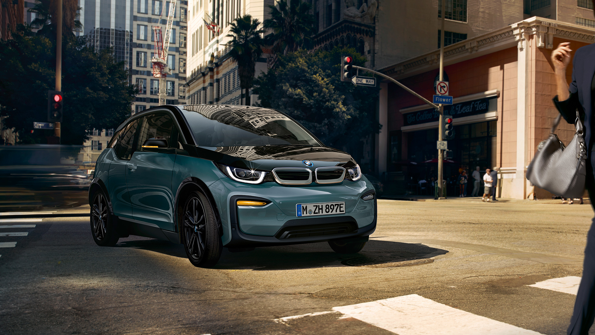BMW i3 2018 three-quarter front view driving BMW i3 I01 2018 Jucaro beige with Frozen Grey metallic highlight three-quarter front view driving in urban setting
