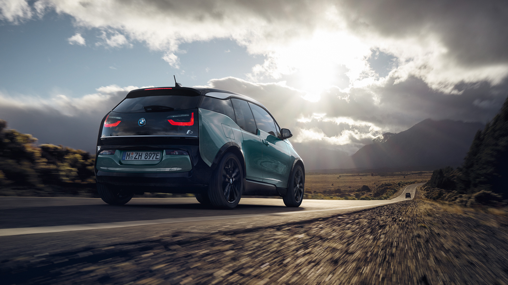BMW i3 2018 three-quarter rear view driving on highway BMW i3 I01 2018 Jucaro beige with Frozen Grey metallic highlight three-quarter rear view driving on highway
